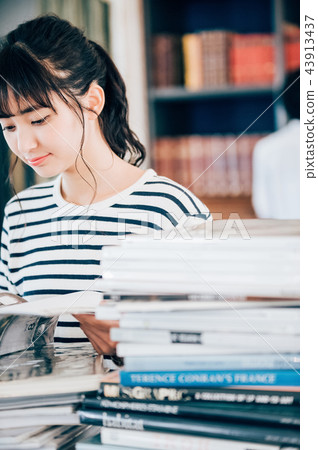 A woman reading a book in a library 43913437