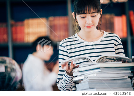 Two people reading a book at the library Two people reading a book at the library 43913548