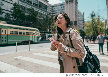 woman looking upward and holding cell phone woman looking upward and holding cell phone 43916179