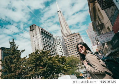 upward view of woman standing in street. upward view of woman standing in street. 43916189