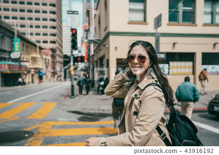 woman walking in street and smiling happily woman walking in street and smiling happily 43916192