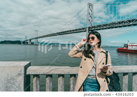 woman holding sunglasses while looking somewhere 43916203