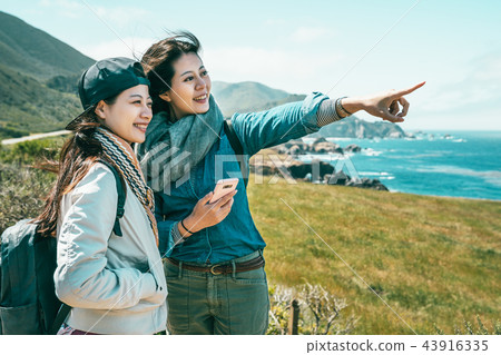 friends looking into ocean standing on coast 43916335