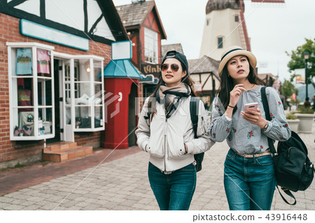 friends walking and looking curiously around 43916448