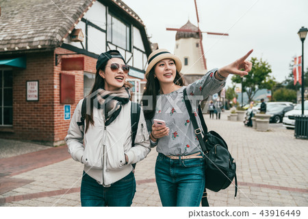sisters traveling in a old town joyfully 43916449