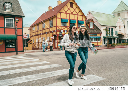 friends crossing road and laughing together 43916455
