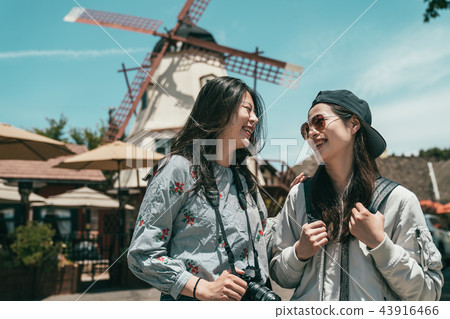 sisters laughing while taking photos. 43916466