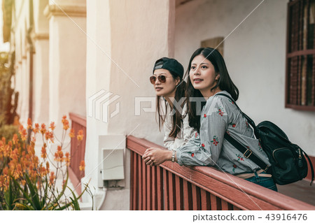 sisters leaning on the guardrail for a break 43916476