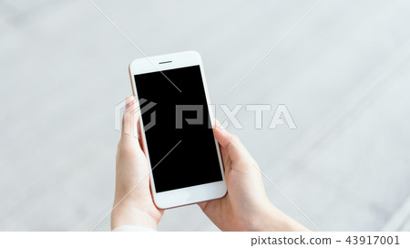 woman using smartphone on staircase in public area 43917001