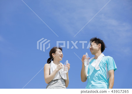 Running jogging marathon men and women hydration blue sky 43917265