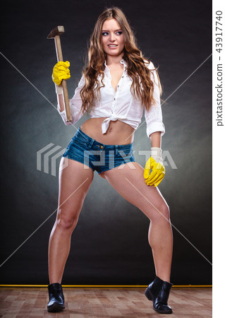 Sexy alluring woman holding hammer. Feminism. 43917740