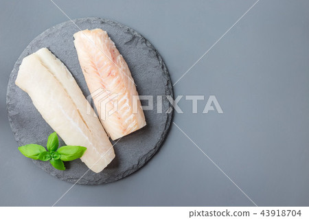 Fresh raw cod fillet with basil on stone plate Fresh raw cod fillet with basil on stone plate 43918704
