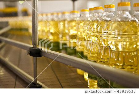 Sunflower oil in the bottle moving on production line. Shallow dof. Sunflower oil in the bottle moving on production line. Shallow dof. 43919533