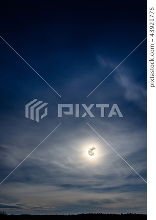A wonderful full moon has descended over Ukrainian carpathians in blurry clouds 43921778