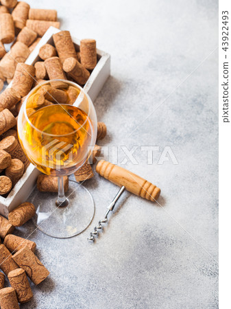 Glass of white wine with box of corks  43922493