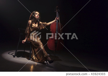 The cellist performs on stage. 43924303