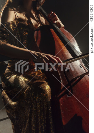 The cellist performs on stage. 43924305