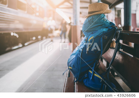 A backpack and hat on the wooden chair. A backpack and hat on the wooden chair. 43926606
