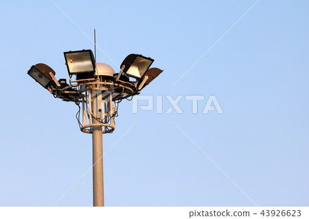 The stadium lights on poles with the sky. 43926623