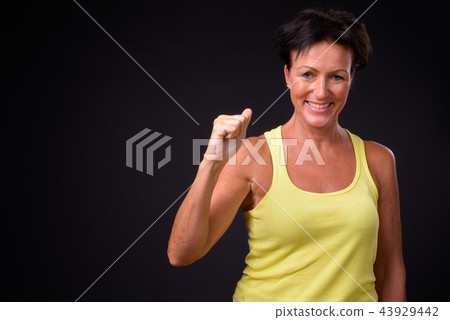 Mature beautiful woman with short hair against black background 43929442