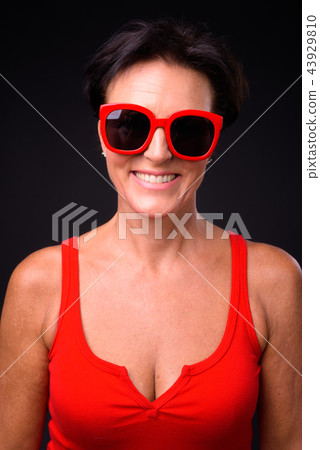 Mature beautiful woman with short hair against black background 43929810
