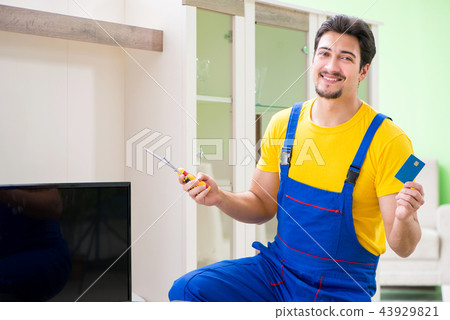 Male professional serviceman repairing tv at home Male professional serviceman repairing tv at home 43929821