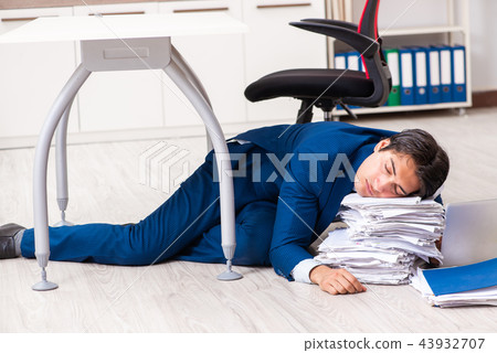 Tired exhausted businessman working overtime in office Tired exhausted businessman working overtime in office 43932707