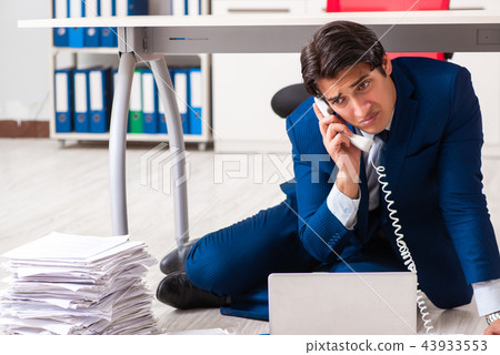 Tired exhausted businessman working overtime in office Tired exhausted businessman working overtime in office 43933553