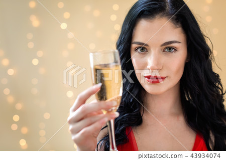 Young woman holding a champagne flute Young woman holding a champagne flute 43934074