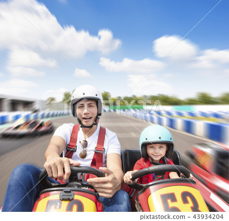 father and daughter driving go kart on the track 43934204