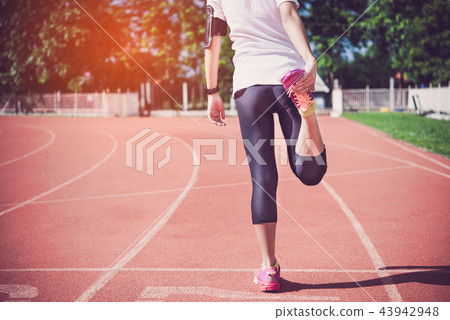 The female runner is warming up before jogging The female runner is warming up before jogging 43942948