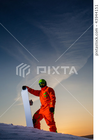 Snowboarder on the top of the ski slope at the background of beautiful sunset Snowboarder on the top of the ski slope at the background of beautiful sunset 43944151