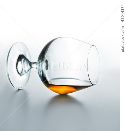 Glass with cognac lying on table top 43944374
