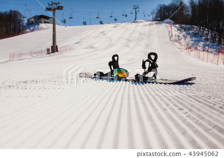 Bottom view on empty ski slope and equipment for snowboarding Bottom view on empty ski slope and equipment for snowboarding 43945062