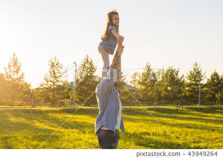 Fatherhood, family and children concept - Father and daughter having fun and playing in nature. Fatherhood, family and children concept - Father and daughter having fun and playing in nature. 43949264