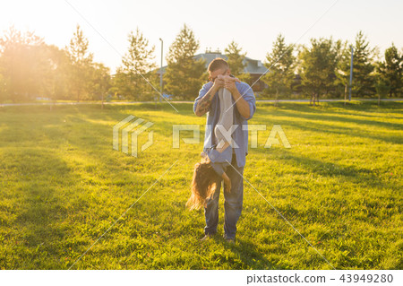 Fatherhood, family and children concept - Father and daughter having fun and playing in nature. Fatherhood, family and children concept - Father and daughter having fun and playing in nature. 43949280