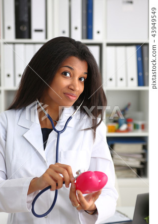 Beautiful black smiling female doctor hold 43949549