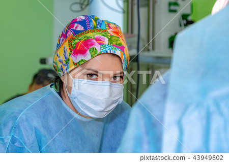 female surgeon doctor wearing protective mask and hat during the operation. Healthcare, medical female surgeon doctor wearing protective mask and hat during the operation. Healthcare, medical 43949802