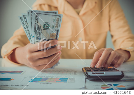 businesswoman using calculator and holding money businesswoman using calculator and holding money 43951648