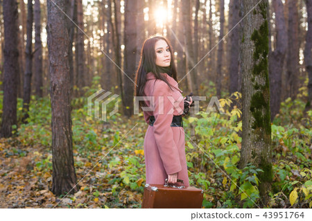 People, season and nature concept - Young woman walking in autumn park People, season and nature concept - Young woman walking in autumn park 43951764
