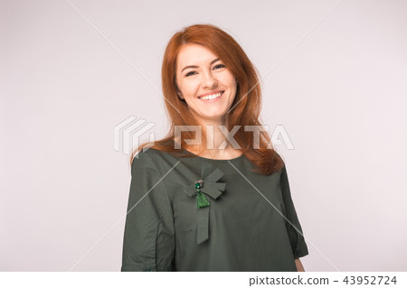 Fashion and people concept - Portrait of happy ginger woman smiling looking at camera over white 43952724