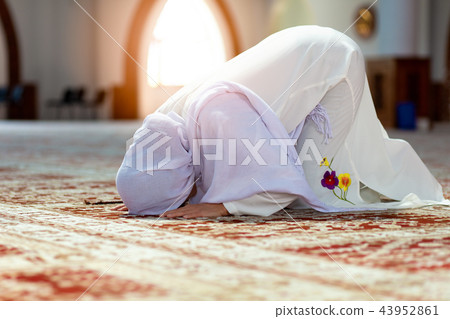 Young praying woman falling on knees in mosque Young praying woman falling on knees in mosque 43952861