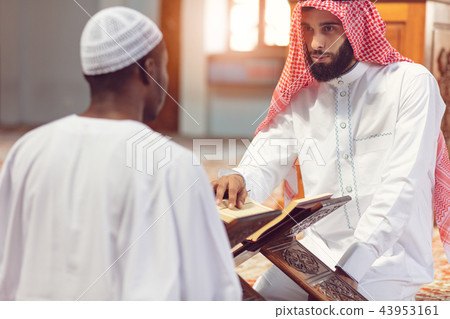 Muslim men praying with holy books in mosque 43953161