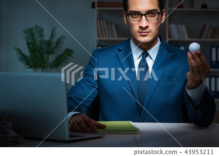 Young employee with golf ball in office Young employee with golf ball in office 43953211