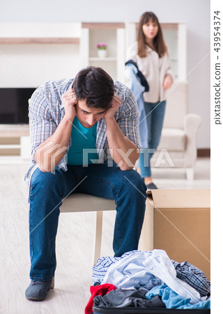 Woman evicting man from house during family conflict 43954374