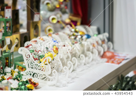 Colorful ornaments, Christmas balls and white wooden sledges. Sale of Christmas decorations 43954543