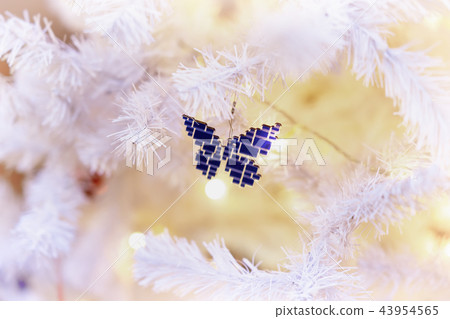 Bright decorations of a glass mosaic butterfly on a white Christmas tree. Festive background for Bright decorations of a glass mosaic butterfly on a white Christmas tree. Festive background for 43954565