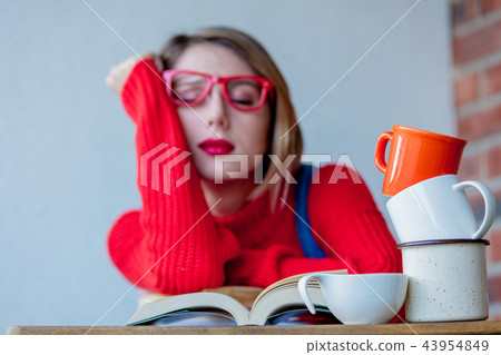 tired girl with cup of coffee and books 43954849