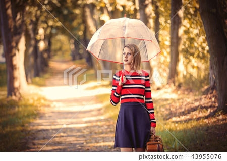 girl with umbrella and suitcase in autumn park girl with umbrella and suitcase in autumn park 43955076