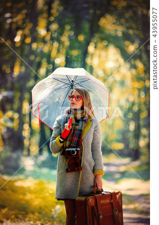 girl with umbrella and suitcase in autumn park girl with umbrella and suitcase in autumn park 43955077